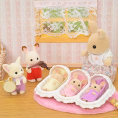 a group of toy mice sitting on top of a wooden floor next to stuffed animals