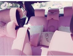 the interior of a car with pink leather seats and bows on the front row seat