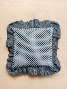 a blue and white pillow with ruffled edges