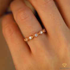 a woman's hand with a diamond ring on top of her finger, showing the band