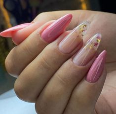 a person with pink and gold nail polish on their nails, holding up her hand