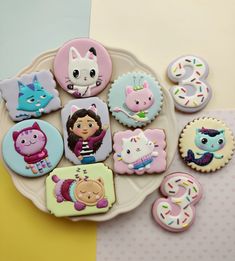 decorated cookies on a plate with pictures of animals and people in the middle one is for 3