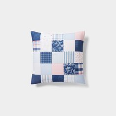 a blue and pink patchwork pillow on a white background