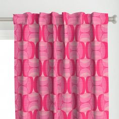 a pink curtain hanging on the side of a window