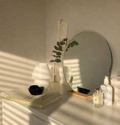 a white dresser topped with a mirror next to a lamp