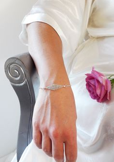 The Bridal Bracelet Gabrielle is composed of a silvery chain and the center of the bracelet is a diamond-shaped divider, hand weaved with galvanised silvery rocaille beads.   The beads used have a "DURACOAT" finish, which means that the metallic colour of the beads will last in time thanks to a process of galvanization.  It will perfectly match the bridal Headband GABRIELLE available in the shop.  This bracelet is 16 cm long with 2 extra rings to adjust the size to your wrist.  -----YOU WILL ALSO LIKE ----- *BRIDAL HEADBAND GABRIELLE*  https://www.etsy.com/fr/listing/779031972/headbandcouronne-mariee-fines-perles?ga_search_query=gabrielle&ref=shop_items_search_2&frs=1 Current creation timeframe: 10 days  ---- For any other personalization/changes please do not hesitate to contact me at con Silver Crystal Bracelet With Diamond Cut, Silver Diamond-cut Crystal Bracelets, Silver Crystal Bracelets With Diamond Cut, Adjustable Diamond White Sterling Silver Bracelet Gift, Wedding Silver Cubic Zirconia Charm Bracelet, Silver Cubic Zirconia Charm Bracelet For Wedding, Silver Diamond-shaped Jewelry, Delicate Silver Chain Bracelet For Party, Crystal Bracelets With Diamond Cut For Gift