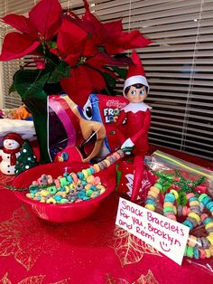 an elf is sitting next to a bowl of candy