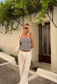 Black and white striped tube top with laced linen pants. Beach outfit. Travel outfit. Outfits for Europe. Pants outfit. Neutral outfits. Pinterest outfits. Outfits for Italy. Outfits for Greece.  Follow my shop @maggierussell1 on the @shop.LTK app to shop this post and get my exclusive app-only content!   fashion inspo | fashion outfits | fashion aesthetic | outfit ideas | clothes for women | luxury aesthetic | minimalist | chic | old money aesthetic | coastal granddaughter | vacation outfits | European outfits | clothing pictures | young adult style | blazer outfit | linen outfit | pearls | necklace | revolve | fashion icon | fashion design | clothes design | clean girl aesthetic | fashion blogger | summer day outfit | outfit | summer 2024 fashion | nighttime outfits | elegant outfits | e European Outfits, Spain Outfit, Italian Summer Outfits, European Fashion Summer, Greece Outfit, Cute Vacation Outfits, Stile Hijab, Striped Tube Top, Summer Holiday Outfits