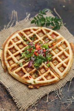 a waffle topped with vegetables on top of a piece of burlocked cloth