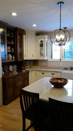 a large kitchen with an island in the middle and lots of cabinets on both sides