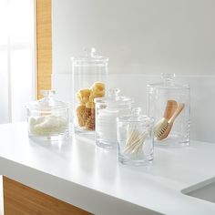 there are many glass containers on the counter