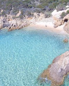 an aerial view of a beach with clear blue water