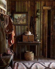 a room with wooden walls and an old fashioned table in the corner, next to a rug