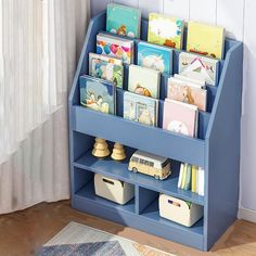 a blue book shelf filled with lots of books next to a white rug and window