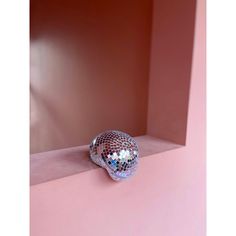 a mirror ball sitting on top of a pink shelf