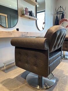 a brown chair sitting in front of a mirror on top of a counter next to a shelf