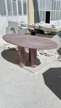 a table sitting on top of a cement slab in the middle of a building yard