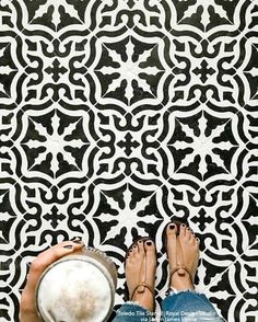 a person standing in front of a black and white tile floor with their feet up