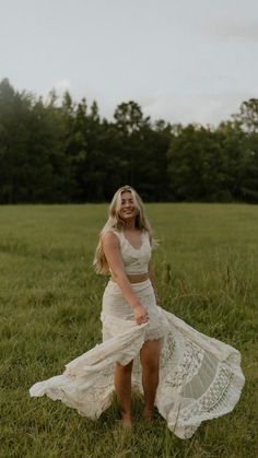 a woman in a white dress is standing in the grass