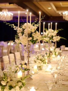 an image of a table setting with flowers and candles on the tables at a wedding