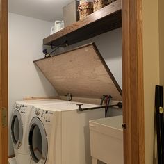 a washer and dryer sitting in a room next to a shelf with baskets on it