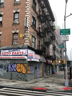 an auto parts store with graffiti on the side of it's building next to a traffic light