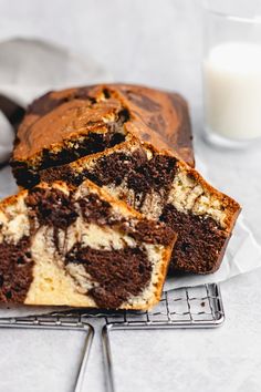 a loaf of chocolate marbled cake on a cooling rack next to a glass of milk