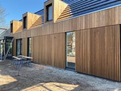 a wooden building with tables and chairs outside