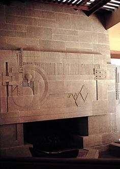 the fireplace is made out of stone and has carvings on it's mantles