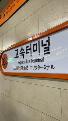 an orange and white sign that says express bus terminal on it's side wall