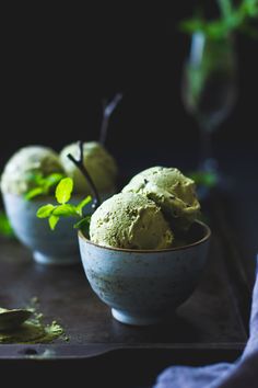 two bowls filled with green ice cream on top of a table