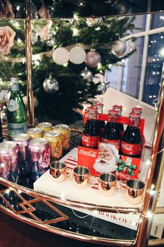 a christmas tree is in the background with bottles and cans