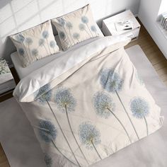 a bed with white sheets and blue flowers on it