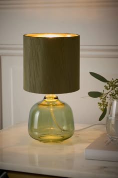 a green lamp sitting on top of a white table