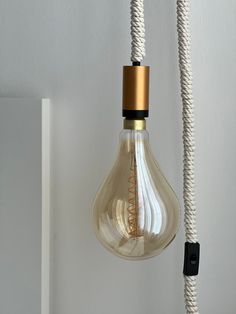 a light bulb hanging from a white wall