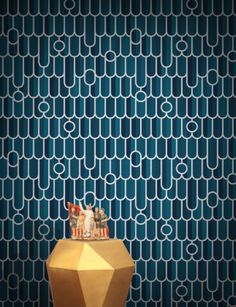 an abstract wallpaper with blue and white circles on the walls, along with two small figurines