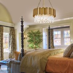 a bedroom with a four post bed and chandelier