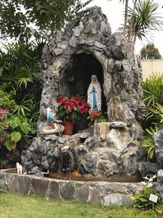 the statue is surrounded by plants and rocks