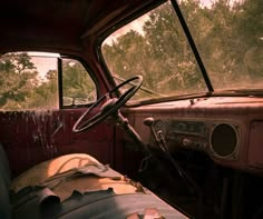 the interior of an old truck with trees in the background