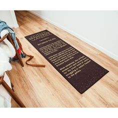 a wooden floor with a poem written on it and a chair in the corner next to it