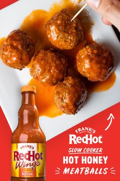 a white plate topped with meatballs next to a bottle of red hot wing sauce