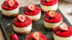 strawberry cheesecakes with whipped cream and fresh strawberries on the top are ready to be eaten