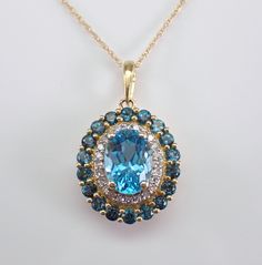 Yellow Gold Blue Topaz and Diamond Pendant Necklace Chain. This pendant is set with an Oval natural Blue Topaz in the center, eighteen Round Blue Topaz and twenty-four Round Brilliant Diamonds. The center Blue Topaz measures 8 X 6 mm and weighs 1 1/2 carats. The small round Blue Topaz amount to a total weight of 3/4 carat. The diamonds in this pendant are H color, I clarity and weighs .15 carat. This pendant and chain are both 10K Yellow gold and weigh a total of 2.8 grams. The pendant measures Halo Necklace, December Birthstone, Diamond Pendant Necklace, Fine Jewelry Gift, Gia Certified Diamonds, Beautiful Gift Boxes, Necklace Chain, Diamond Pendant, Round Brilliant