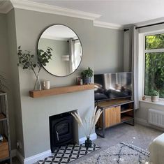 a living room filled with furniture and a fire place in front of a tv mounted on a wall