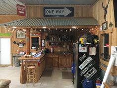 the inside of a garage with several signs on the wall and two bar stools