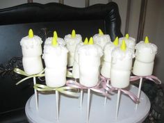 there are many candles that have been decorated with yellow and white frosting on them