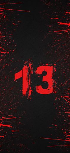 the number thirteen is painted red on a black background with paint splattered over it