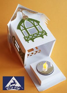 a small white box with a candle in it