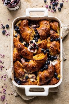 a casserole with blueberries and cream in it on top of a table