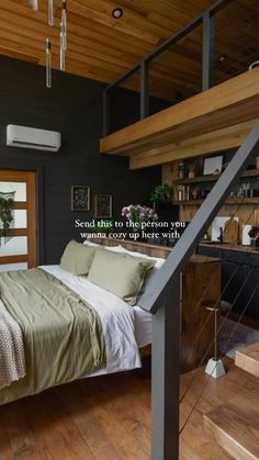 a bed sitting under a stair case next to a wooden floor in a room with black walls